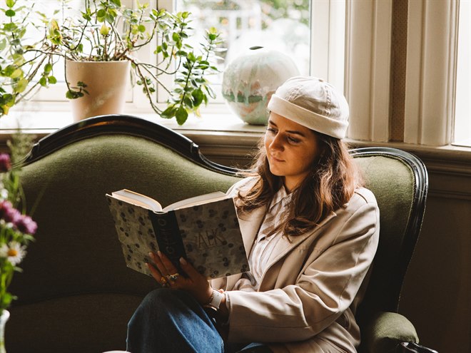 Kvinna som läser i loungen. Bild.