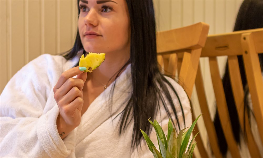 A women in the relaxing area eating fruit. Image.