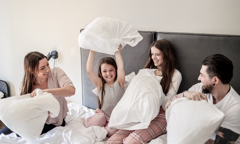 A family of four in one bed in a Standard Family Room.