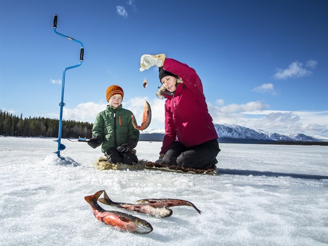 En mamma och hennes son är på isfiske.