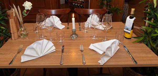 Dining table decorated with candles and flowers. Photo.