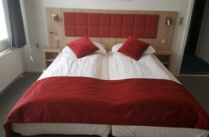 Triple hotelværelse med rød indretning. Bilde.