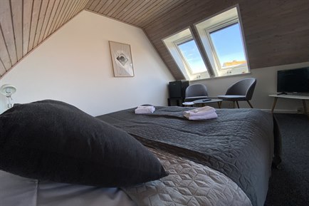 Triple Room with grey furniture. Photo.