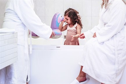 Två vuxna personer och ett barn i en jacuzzi.