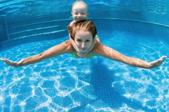 A mother with a child under water. Image.