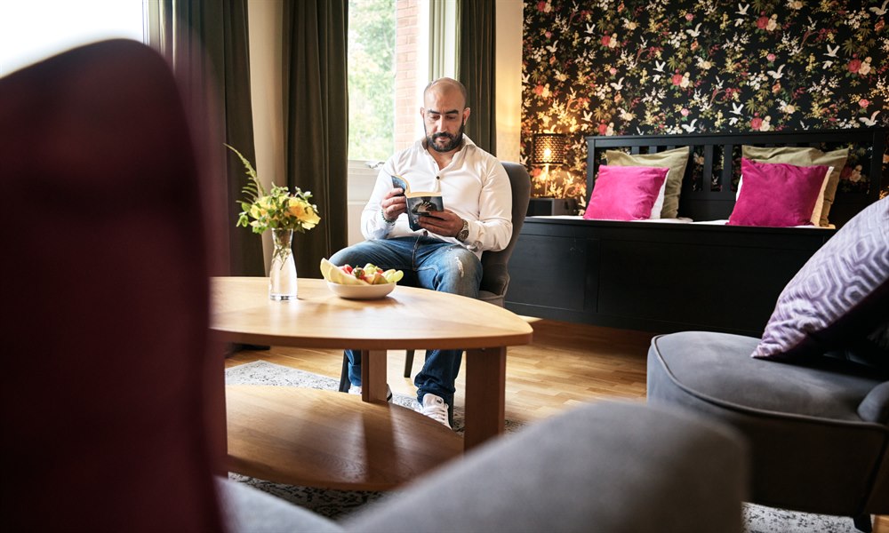 Koselig hotellrom med sofa. Bilde.