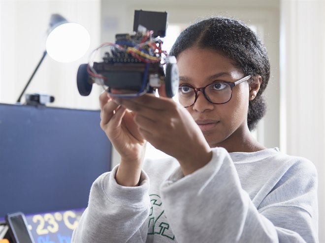 En tjej undersöker sin tekniska skapelse.