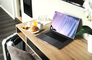 Frukost och en dator på ett skrivbord. Bild.