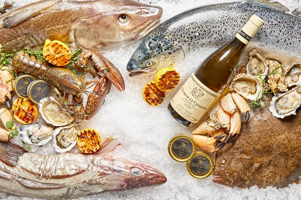 Fisk og skaldyr, fisk og vin på en isleje. Billede.