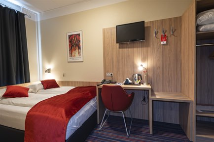 Small double room with red furniture. Photo.