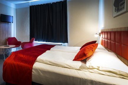 Superior double room with red decorate. Photo.