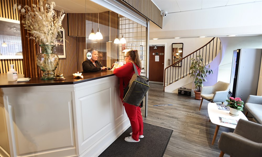 Two persons at the hotel's front desk. Image.