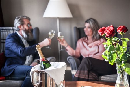 Two people in each armchair and a bottle of bubbly.