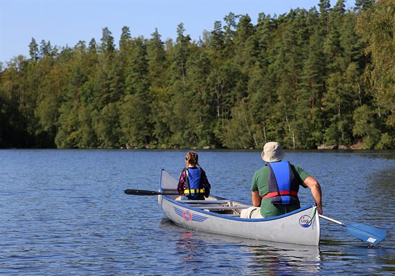 Two people in a canoe on a lake. Image.