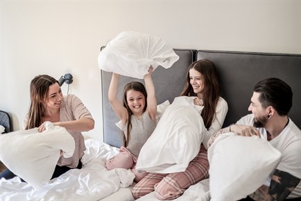 A family of four in one bed in a Standard Family Room.