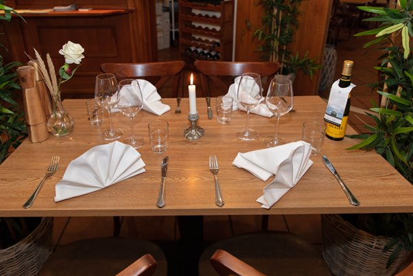 Dining table decorated with candles and flowers. Photo.