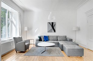 Moderne møbler i stua treroms leilighet. Bilde.