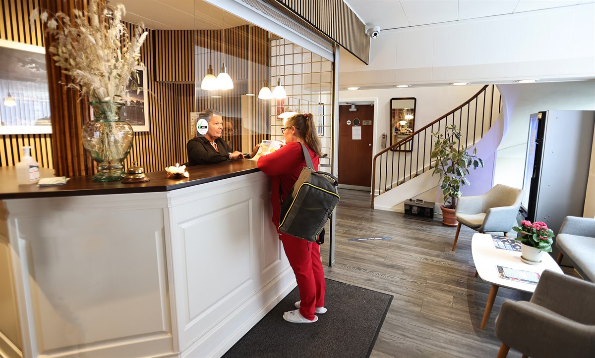 Two persons at the hotel's front desk. Image.