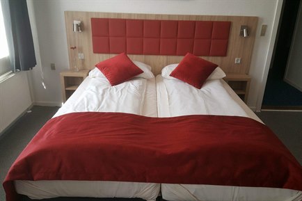 Triple room with red decorate. Photo.