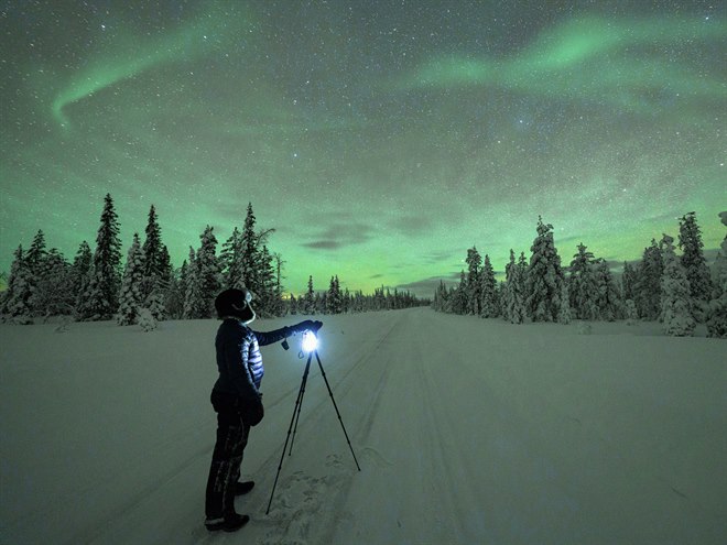 En person fotograferar norrsken.