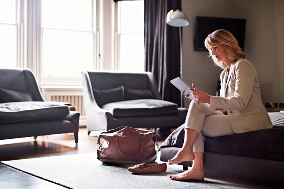 A business woman with a laptop in a hotel room.