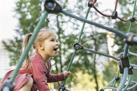 a child climbs in a climbing frame