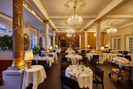 Several set restaurant tables in the restaurant. Image.