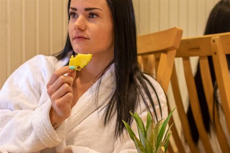 A women in the relaxing area eating fruit. Image.