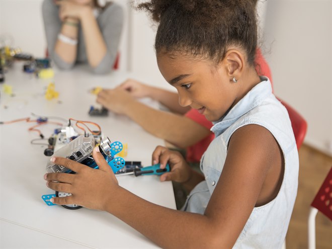 En tjej jobbar på sin tekniska skapelse.