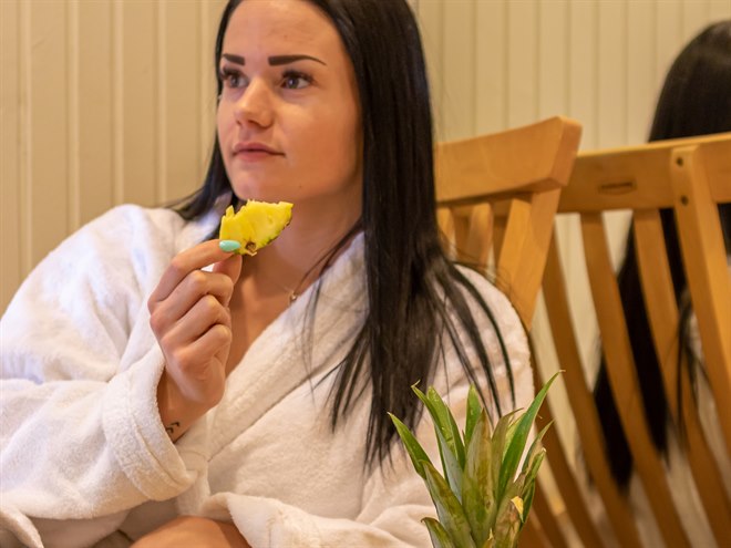 En kvinna i det avkopplande området som äter frukt. Bild.