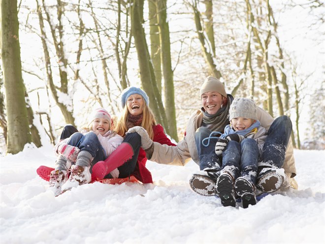En familj på fyra åker pulka.