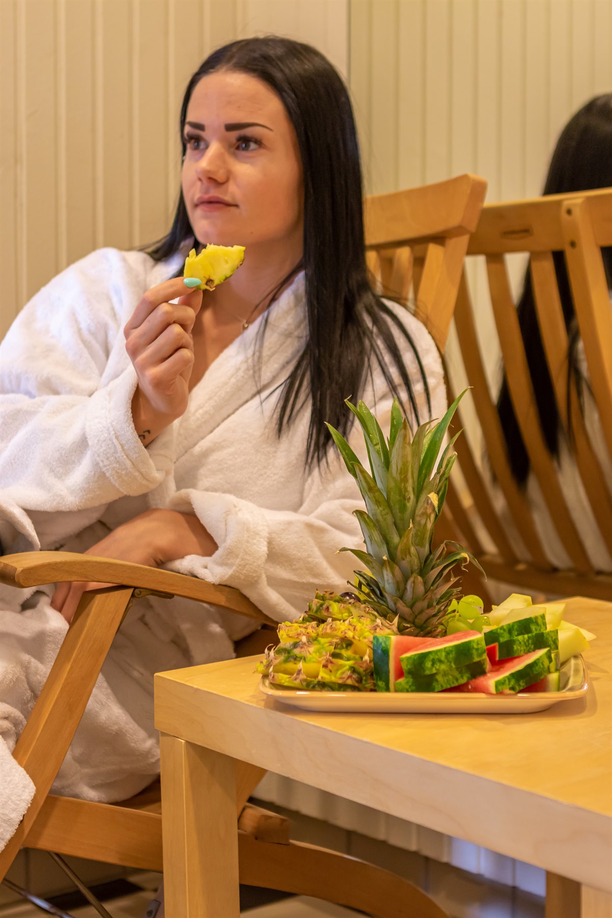 A women in the relaxing area eating fruit. Image.