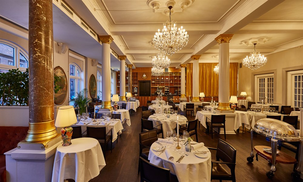 Flere dækkede restaurantborde i restauranten. Billede.