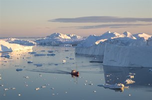 A red fishing boat on the Ilulissat Icefjord. Image.