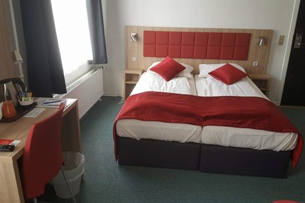 Triple room with red decorate. Photo.