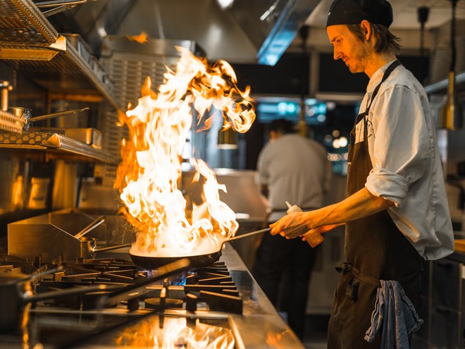 Kock flamberar mat i restaurangen