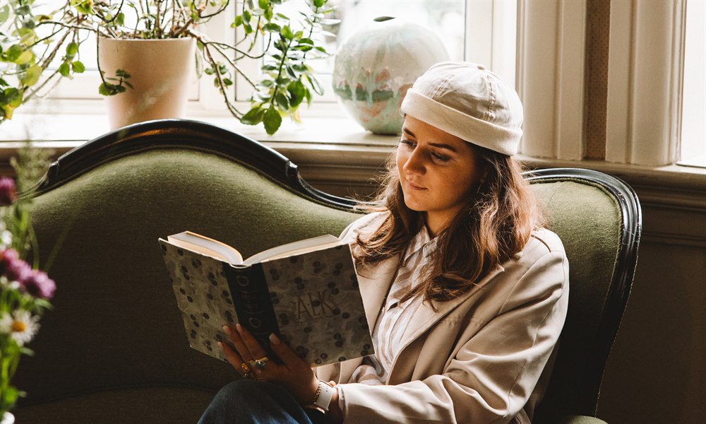 Kvinna som läser i loungen. Bild.