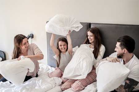 A family of four in one bed in a Standard Family Room.