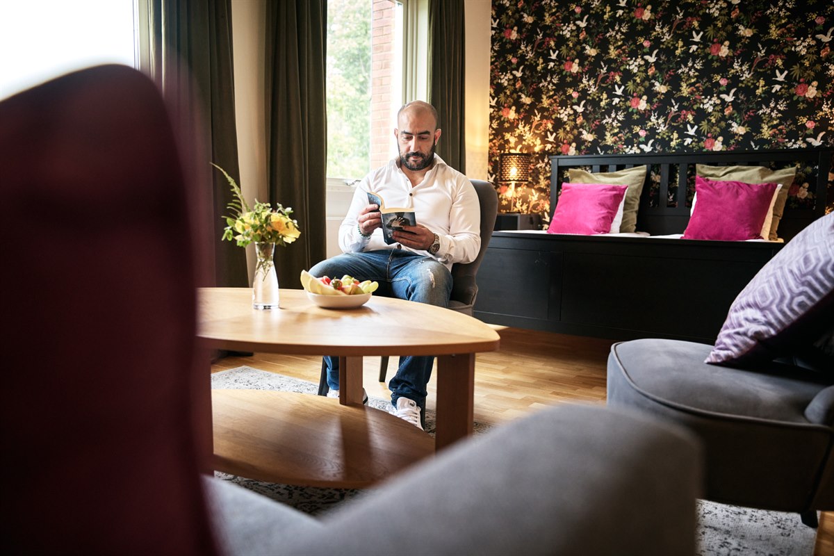 Koselig hotellrom med sofa. Bilde.