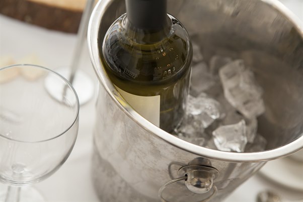 A wine bucket with ice and glasses. Image.